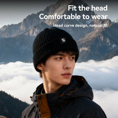 Person wearing a black knit beanie with a mountainous background